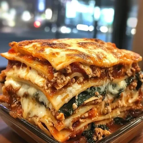 Sliced portion of chicken mushroom spinach lasagna showing distinct layers
