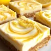 Finished lemon marbled cheesecake bars with fresh berries