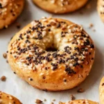 Freshly baked high protein bagels with everything seasoning on parchment paper
