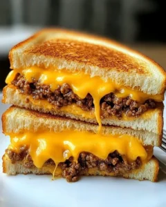 Completed ground beef grilled cheese sandwich served with tomato soup