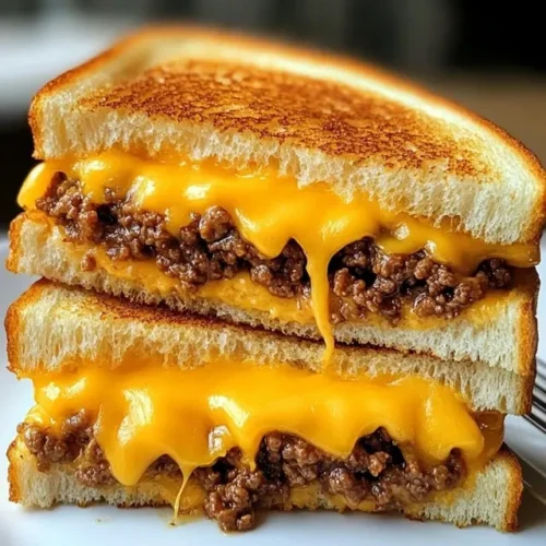 Completed ground beef grilled cheese sandwich served with tomato soup