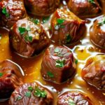 Slow cooker garlic butter beef bites served over mashed potatoes with fresh parsley garnish