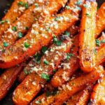Fresh carrots, Parmesan cheese, garlic, and herbs arranged for roasted carrot recipe