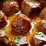 Beef cubes cooking in slow cooker with garlic butter sauce