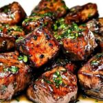 Searing steak bites with stew meat in hot skillet with golden brown crust