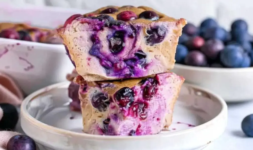 Cottage cheese breakfast bake ingredients including cottage cheese, oats, blueberries, bananas, and egg arranged on counter