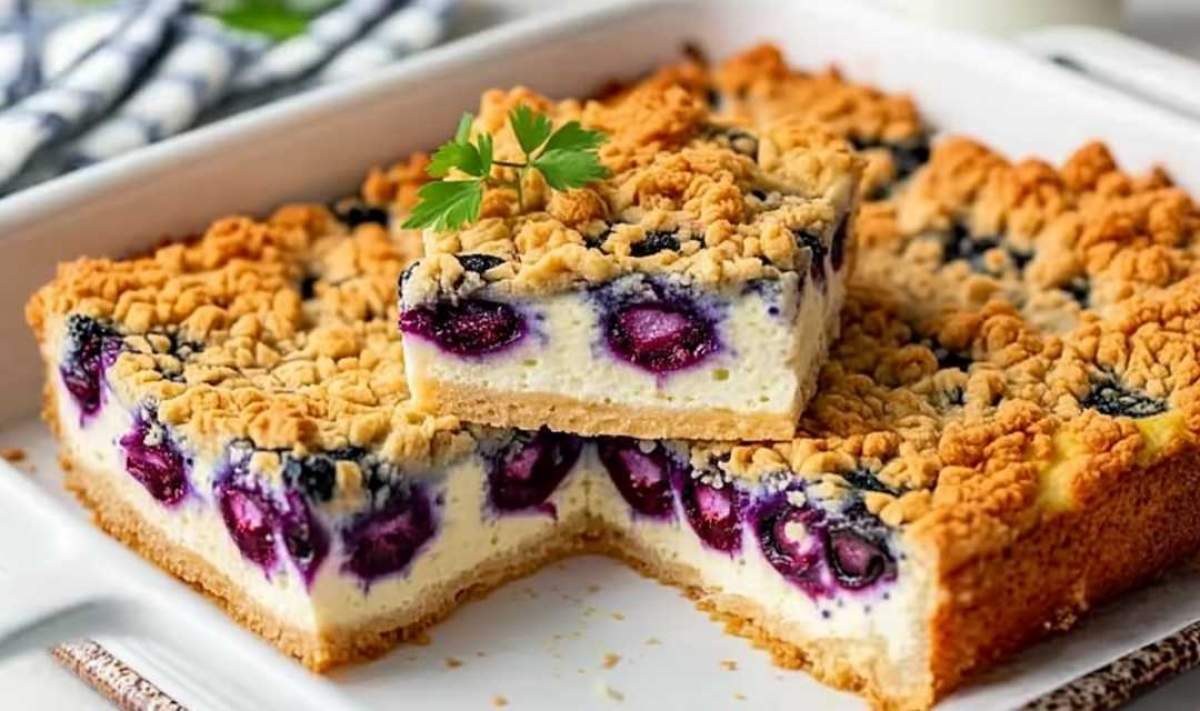 Slice of Cottage Cheese Breakfast Bake on white plate showing creamy interior with blueberries and crumble topping