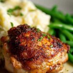 Crispy baked chicken thighs served with roasted vegetables on dinner plate