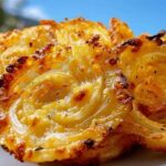 Easy cheesy onion crisp with golden melted cheddar cheese on baking sheet