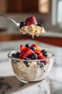 High protein overnight oats topped with fresh berries in a mason jar