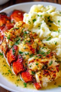 Elegant plated baked lobster tails with garlic herb butter and mashed potatoes ready to serve