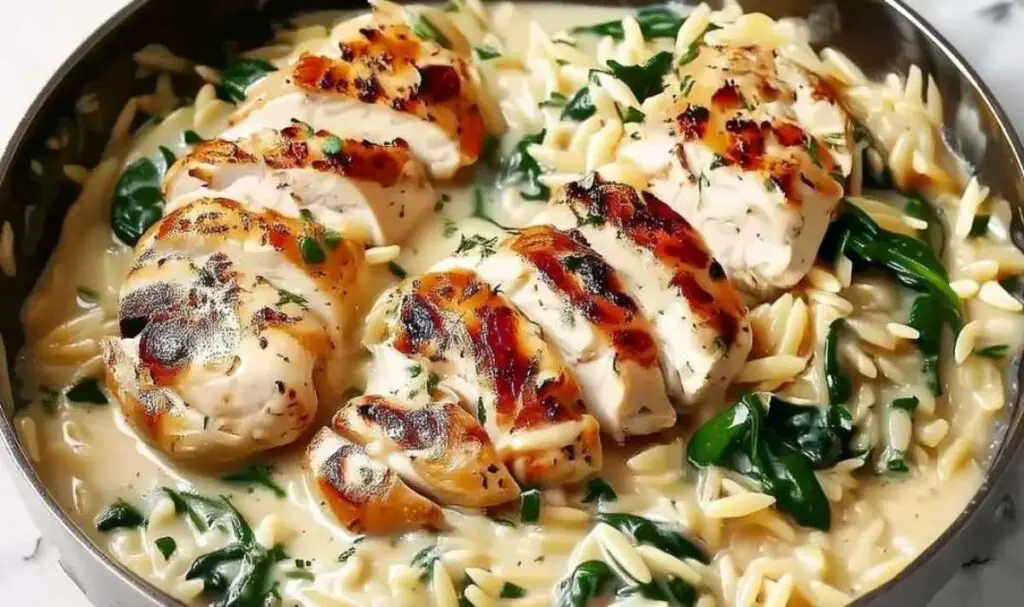 Orzo pasta cooking in chicken broth in a large skillet for Boursin orzo recipe