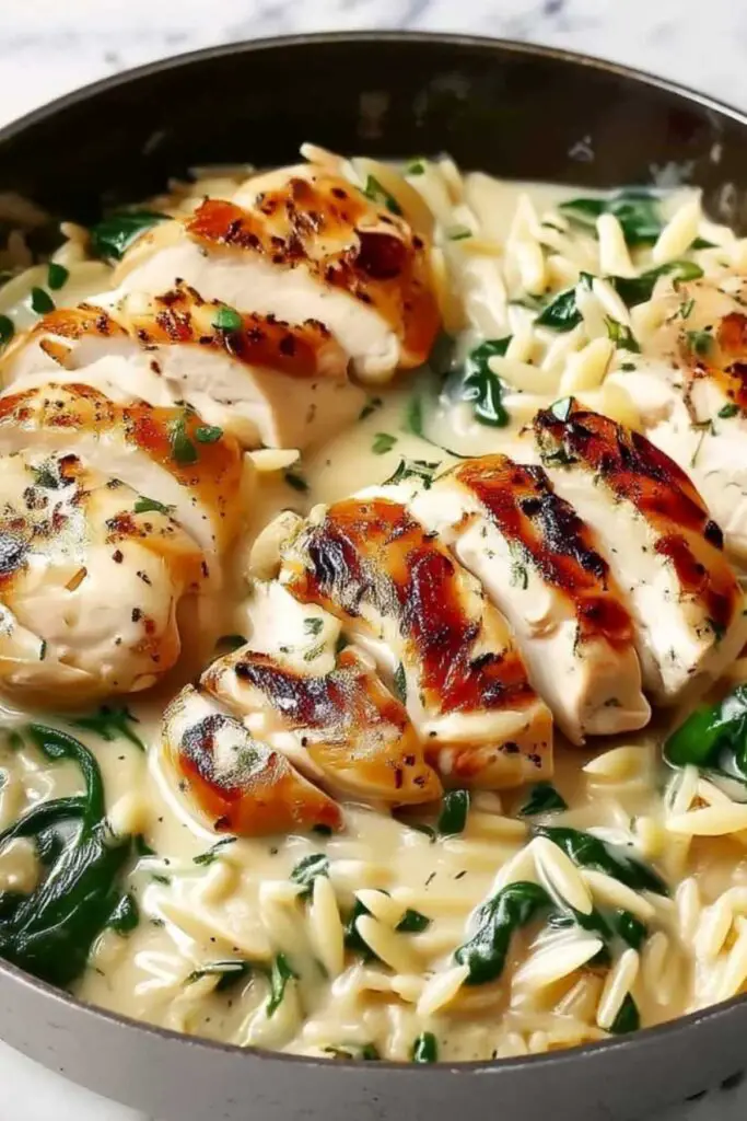 Creamy Boursin orzo with chicken served in a skillet with fresh parsley garnish