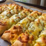 Golden baked cheesy garlic breadsticks fresh from the oven with melted mozzarella cheese