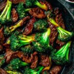 Chinese beef and broccoli recipe served over white rice in blue bowl