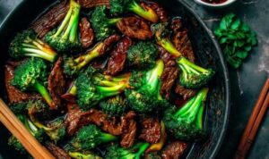 Chinese beef and broccoli recipe served over white rice in blue bowl