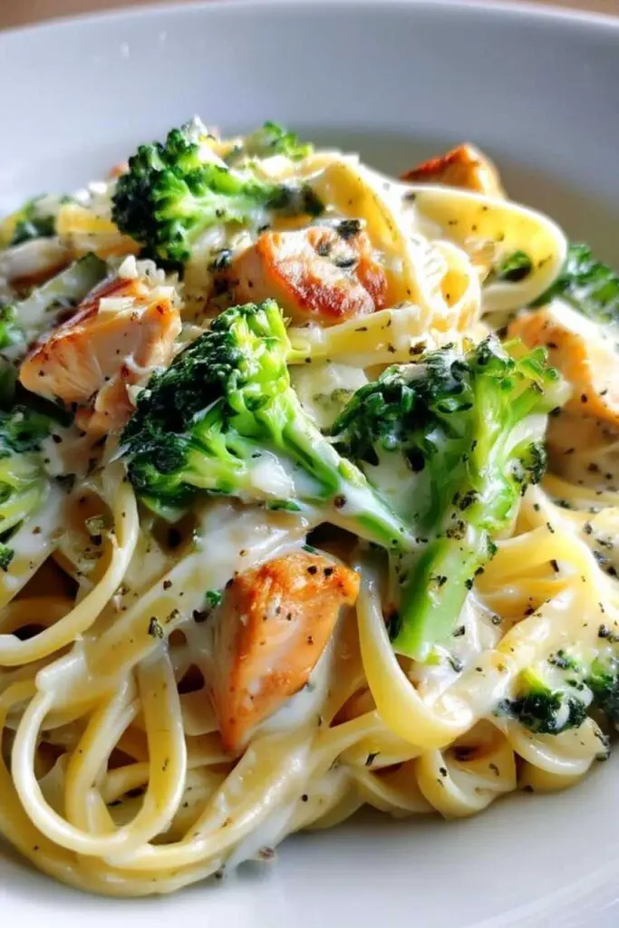 Creamy chicken and broccoli pasta in a large skillet with melted Parmesan sauce