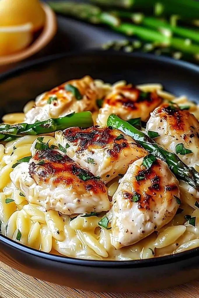Orzo pasta cooking in chicken broth in large skillet for creamy Parmesan orzo chicken recipe