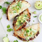 Crispy black bean tacos served with toppings and lime wedges