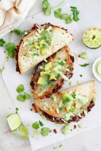 Crispy black bean tacos served with toppings and lime wedges