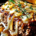 Sliced French onion meatloaf showing tender interior with melted cheese and caramelized onions
