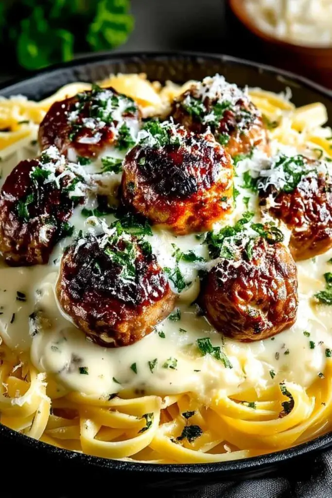 Garlic butter meatballs linguine served in white bowl with fresh parsley and parmesan cheese