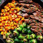 Garlic butter steak with Brussels sprouts and butternut squash served on white plate