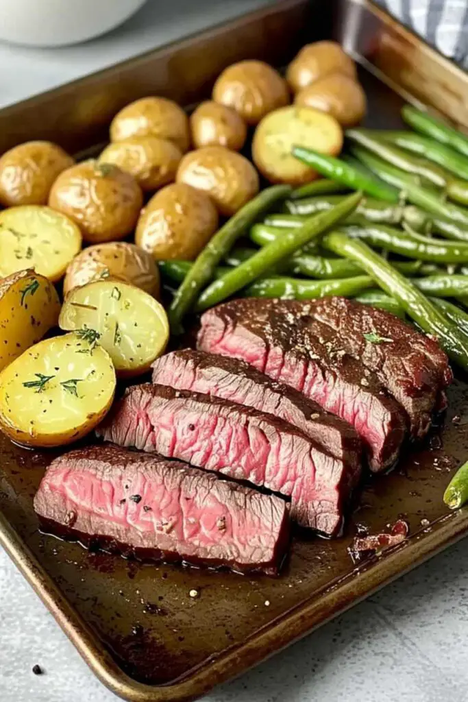 Fresh steak, baby potatoes, and green beans prepped for herbed steak sheet pan dinner