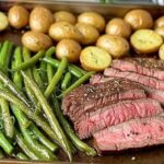 Sliced herbed steak with roasted vegetables plated for serving