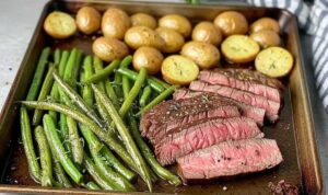 Sliced herbed steak with roasted vegetables plated for serving