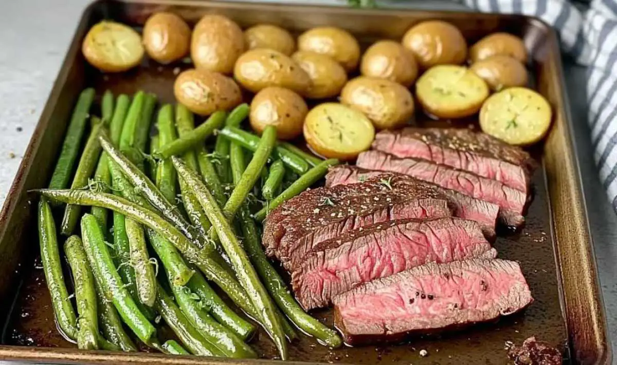 Sliced herbed steak with roasted vegetables plated for serving