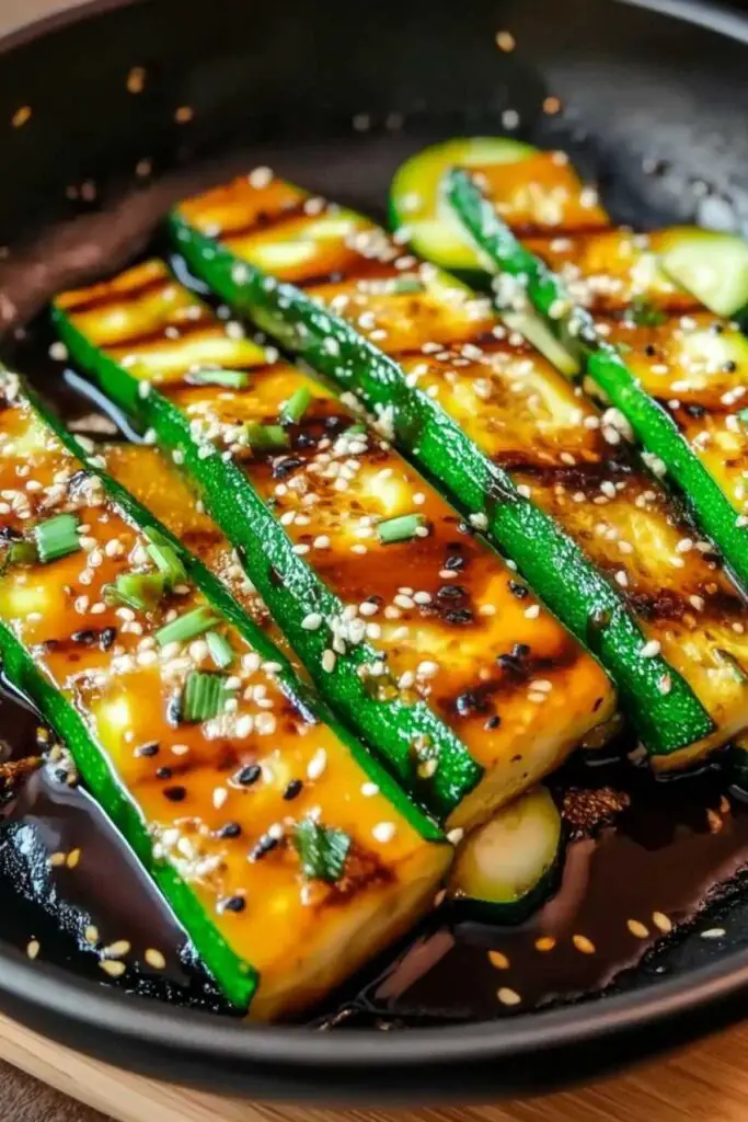 Hibachi zucchini garnished with sesame seeds and green onions on white plate