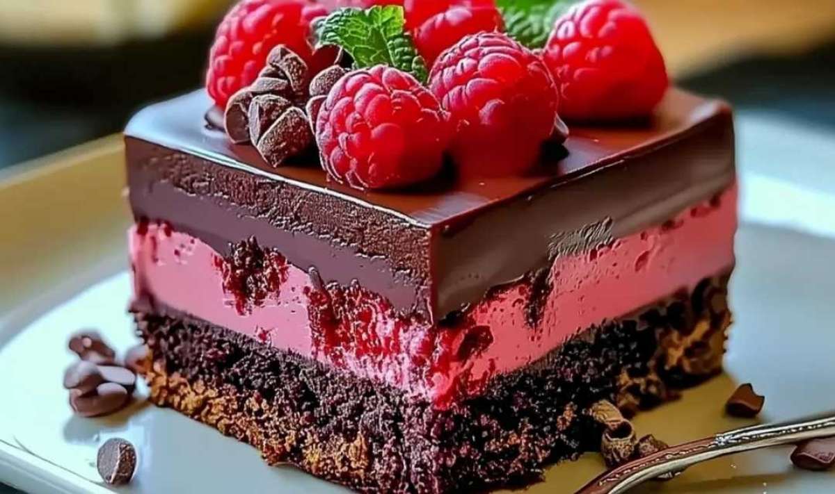 Chocolate ganache being poured over raspberry chocolate mousse cake creating glossy finish