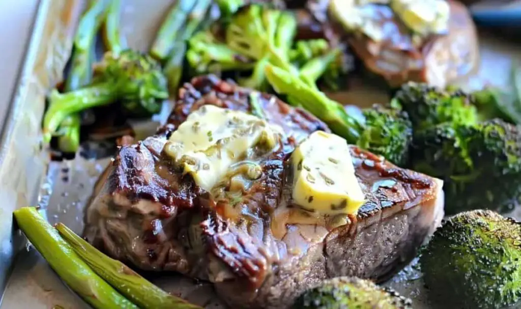 Sliced keto steak topped with rosemary caper butter from sheet pan dinner