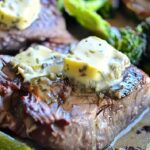 Sliced keto steak topped with rosemary caper butter from sheet pan dinner