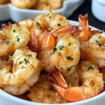Golden brown magic crispy baked shrimp with fresh parsley garnish served on white plate