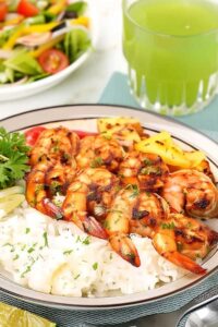 Marinated grilled shrimp served over rice with grilled pineapple and bell peppers