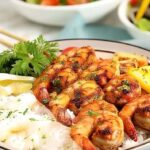 Marinated grilled shrimp served over rice with grilled pineapple and bell peppers