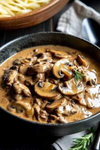 Raw beef chuck and mushrooms in slow cooker before cooking Martha Stewart beef stroganoff