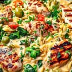Searing chicken breasts for Mediterranean creamy chicken orzo in large skillet
