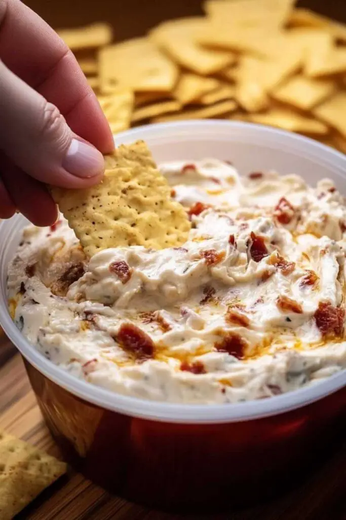 No Name Dip Recipe layered with cheese, salsa, and fresh toppings in white serving dish