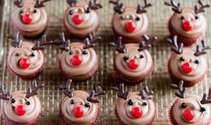 Easy reindeer cupcakes with chocolate antlers and red noses arranged on festive holiday platter