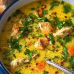 Anti-inflammatory turmeric chicken soup in white bowl garnished with cilantro