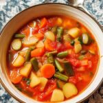 Fresh vegetable soup in white bowl with carrots celery potatoes