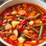 Fresh vegetable soup in white bowl with carrots celery potatoes