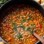 Bowl of Italian lentil soup garnished with parsley and parmesan cheese