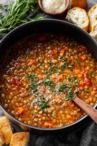 Bowl of Italian lentil soup garnished with parsley and parmesan cheese