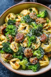 Creamy garlic parmesan tortellini with sausage and broccoli in a large skillet