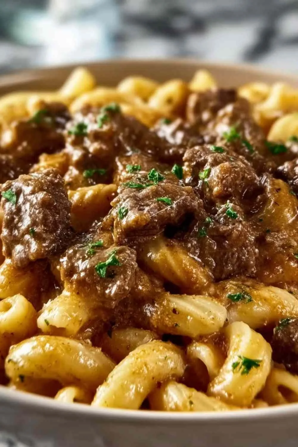 reamy garlic beef pasta served on white plate with fresh parsley garnish