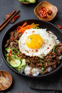 High protein chili in white bowl topped with Greek yogurt and green onions